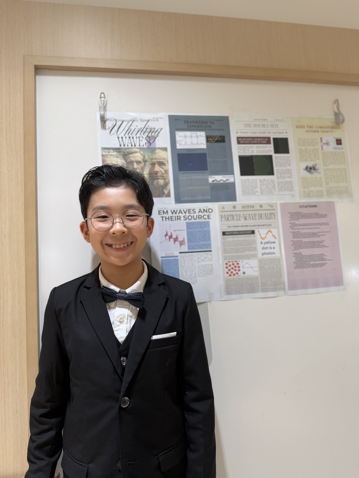 Jian standing in front of the printed Whirling Waves magazine pages